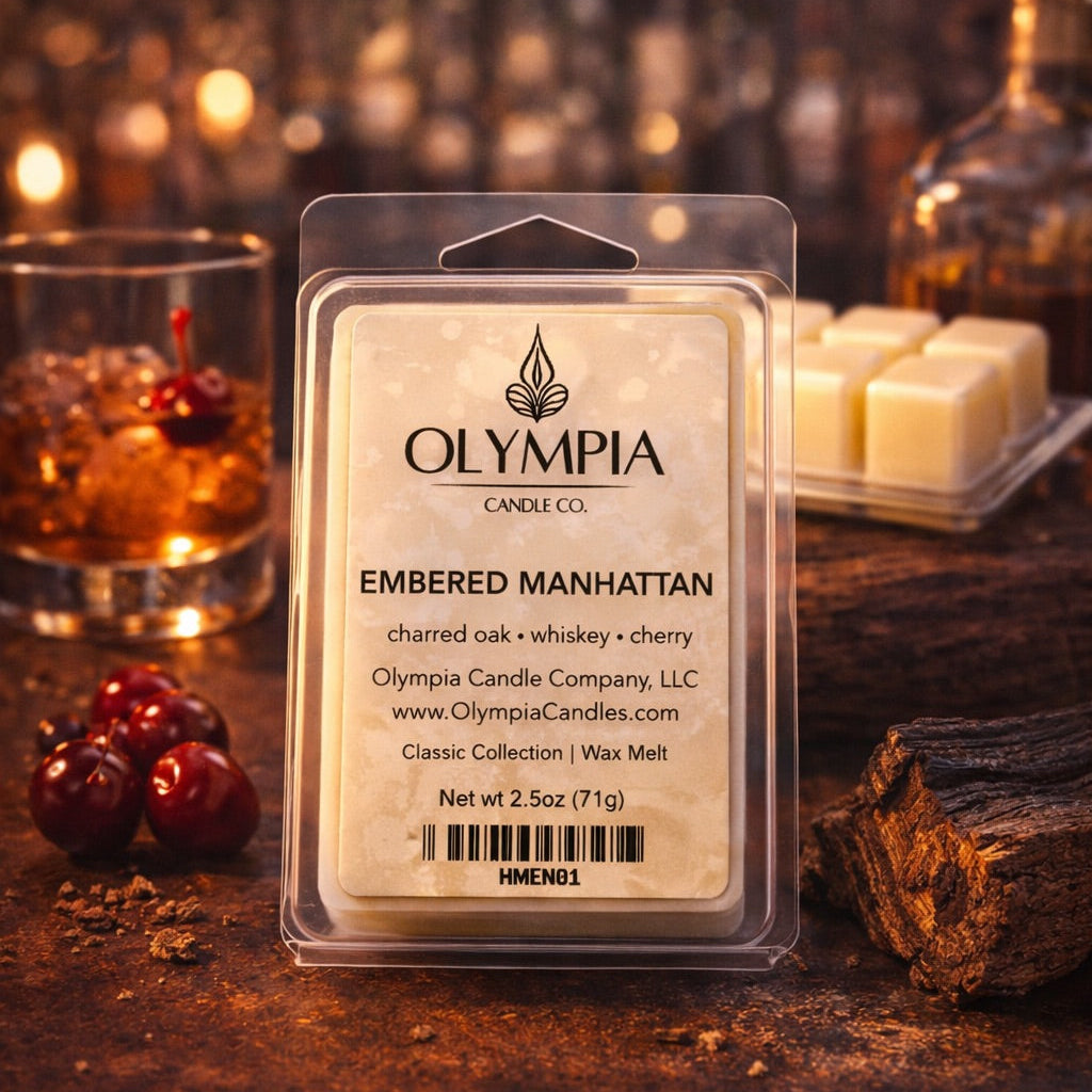 Olympia Candle Co. wax melt package on a wooden surface with a cocktail and cherries in the background