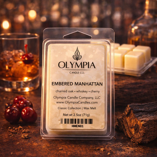 Olympia Candle Co. wax melt package on a wooden surface with a cocktail and cherries in the background