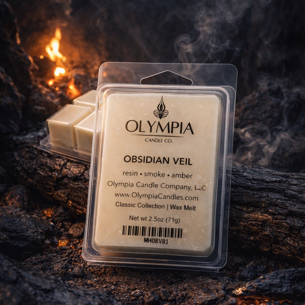 Packaged wax melts with Olympia Candle Co. label on a dark, textured surface with smoky effect