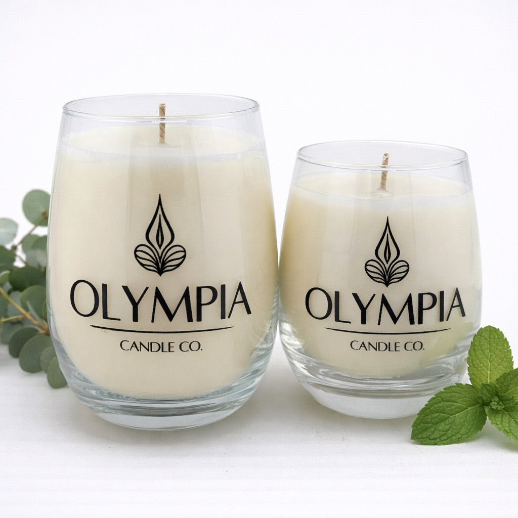 Two glass candles with 'Olympia Candle Co.' logo on a white background