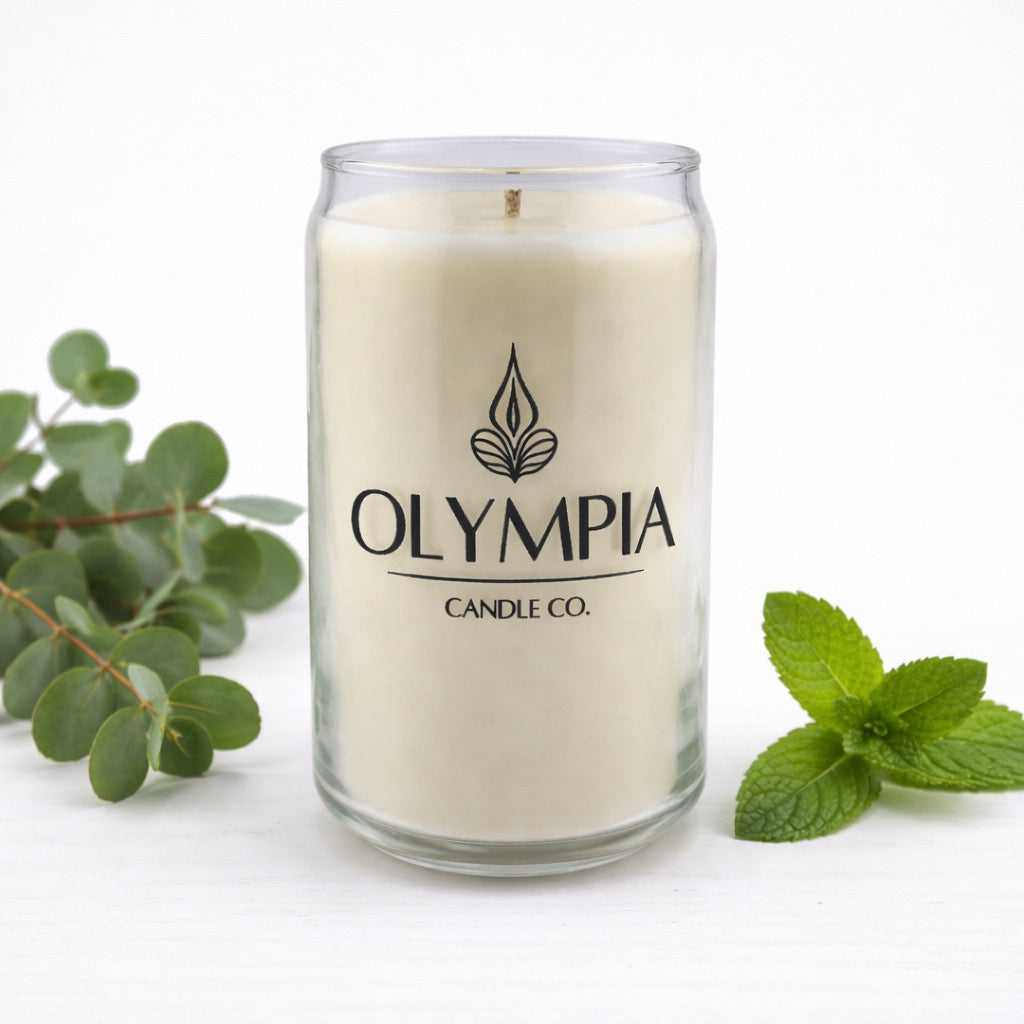 Candle from Olympia Candle Co. with green leaves on a white background