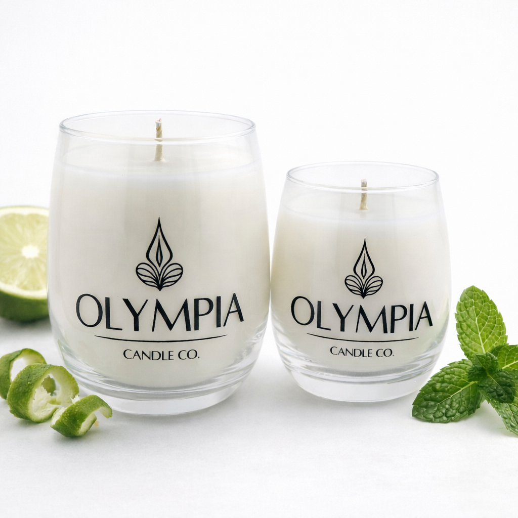 Two glass candles from Olympia Candle Co. with a lime and mint leaves on a white background