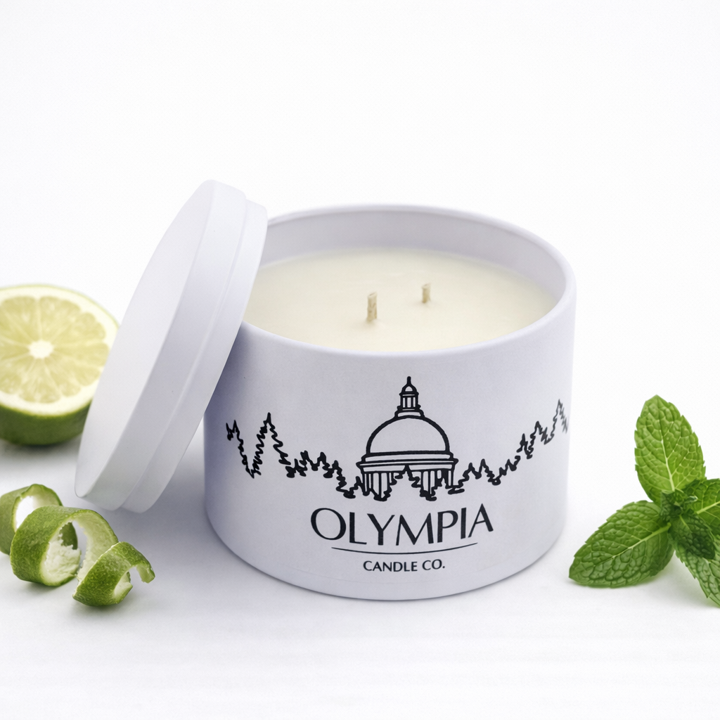Olympia Candle Co. candle in a white container with a bergamot and mint leaves on a white background