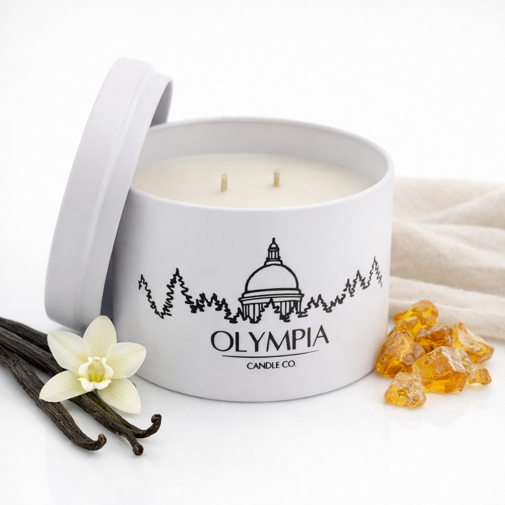 Olympia Candle Co. candle in a tin with vanilla beans and amber gels on a white background